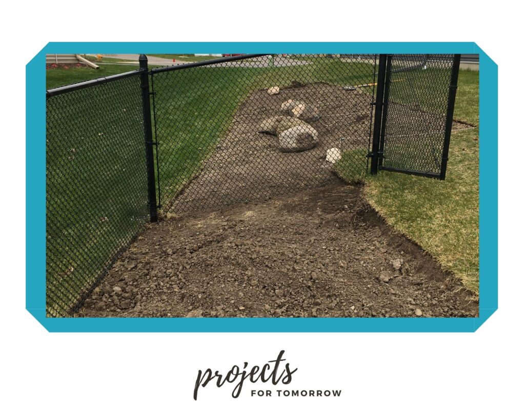 sod removed from side yard, small boulders, black chain link fence